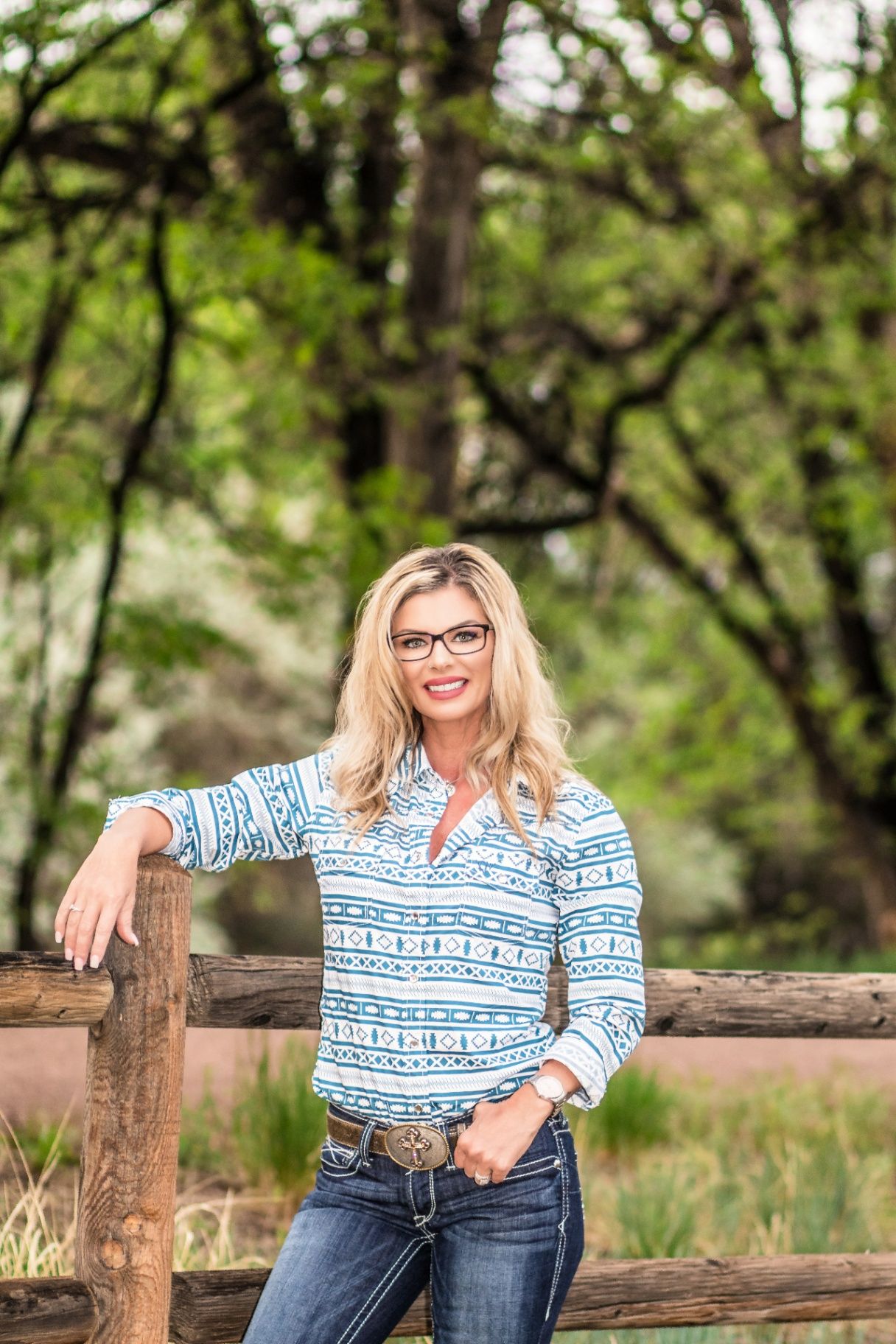 Misty Garman, licensed real estate broker, at a ranch fence in Colorado